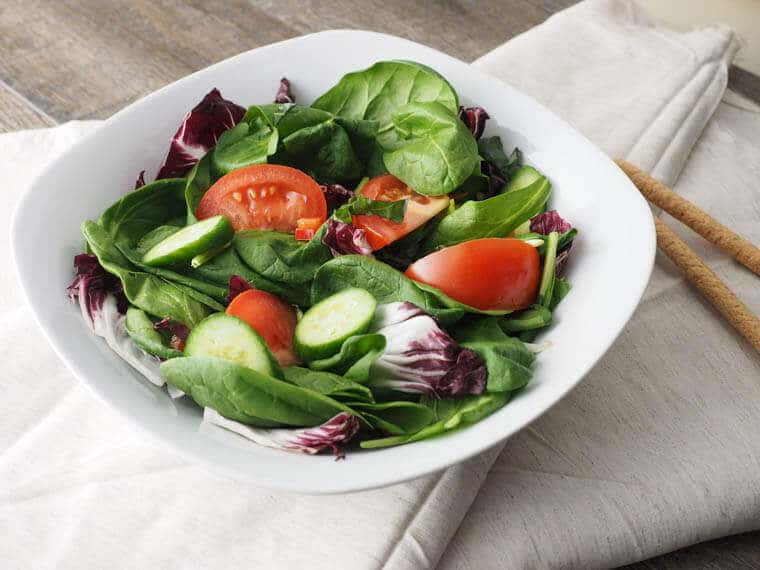 A white plate with a garden salad.