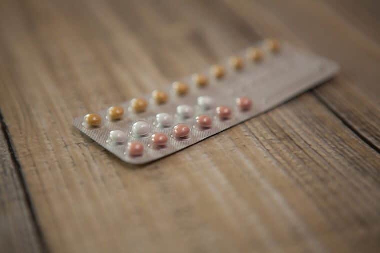 A close up of multi-coloured pills in a pack.