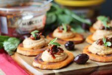 A serving board with multiple sundried tomato sweet potato bites.