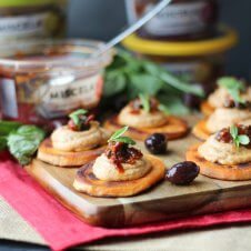 A serving board with multiple sundried tomato sweet potato bites.