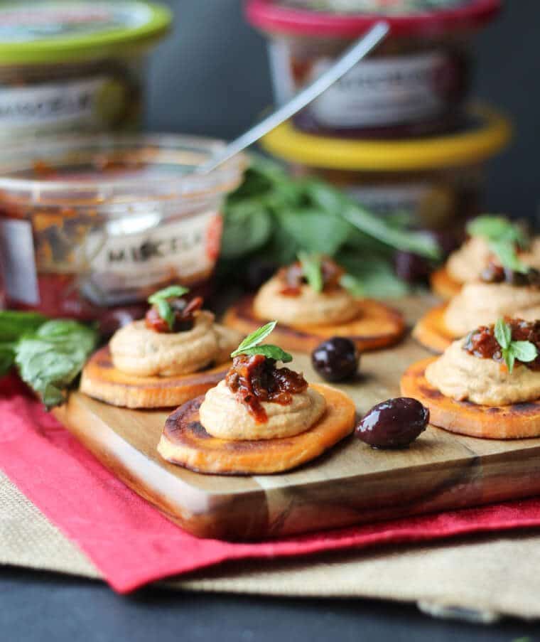 A serving board with multiple sundried tomato sweet potato bites.