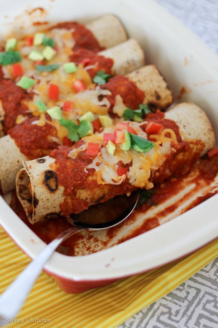 A close up of chicken enchiladas in a baking dish.