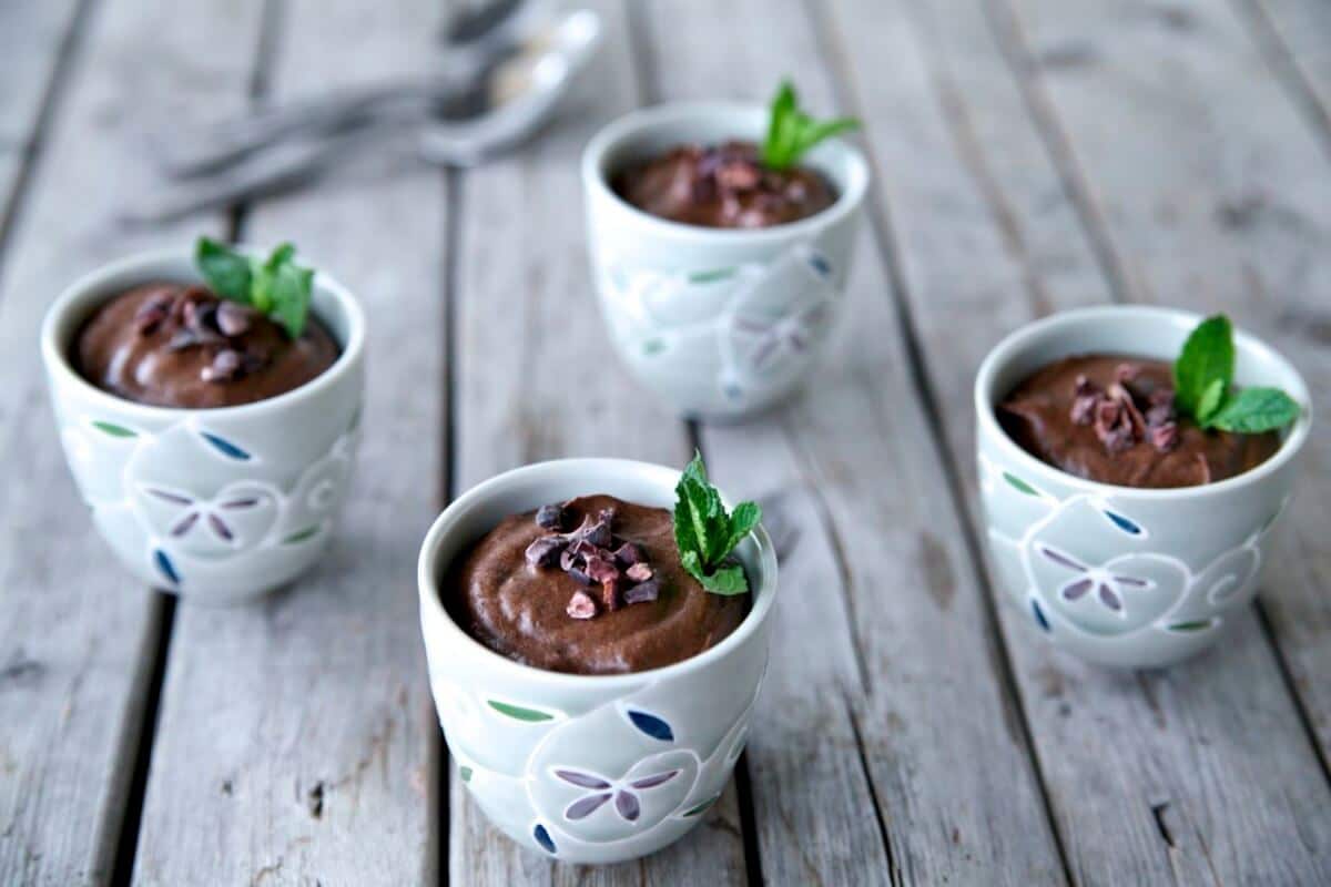 Four small cups of avocado chocolate mousses.