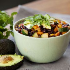 A green bowl of soup with beans.