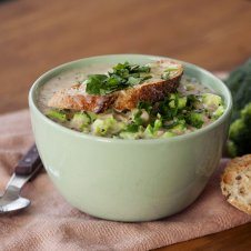 A bowl of soup with toast on top.