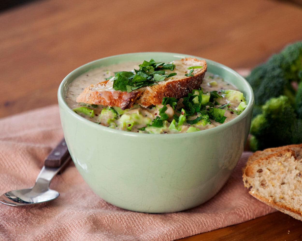 A bowl of soup with toast on top.