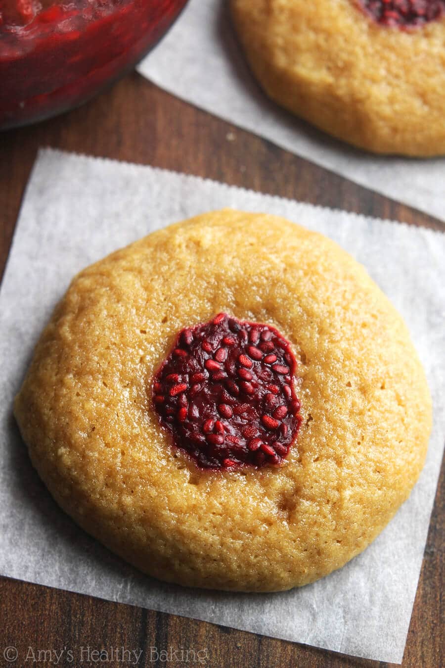 A close up of a raspberry thumbprint cookie.