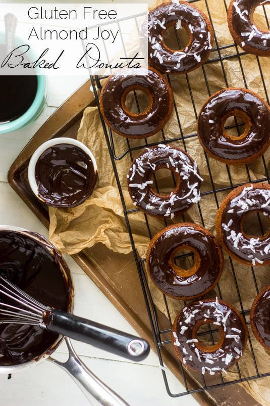 Multiple chocolate donuts on a wire rack overtop a sheet pan.