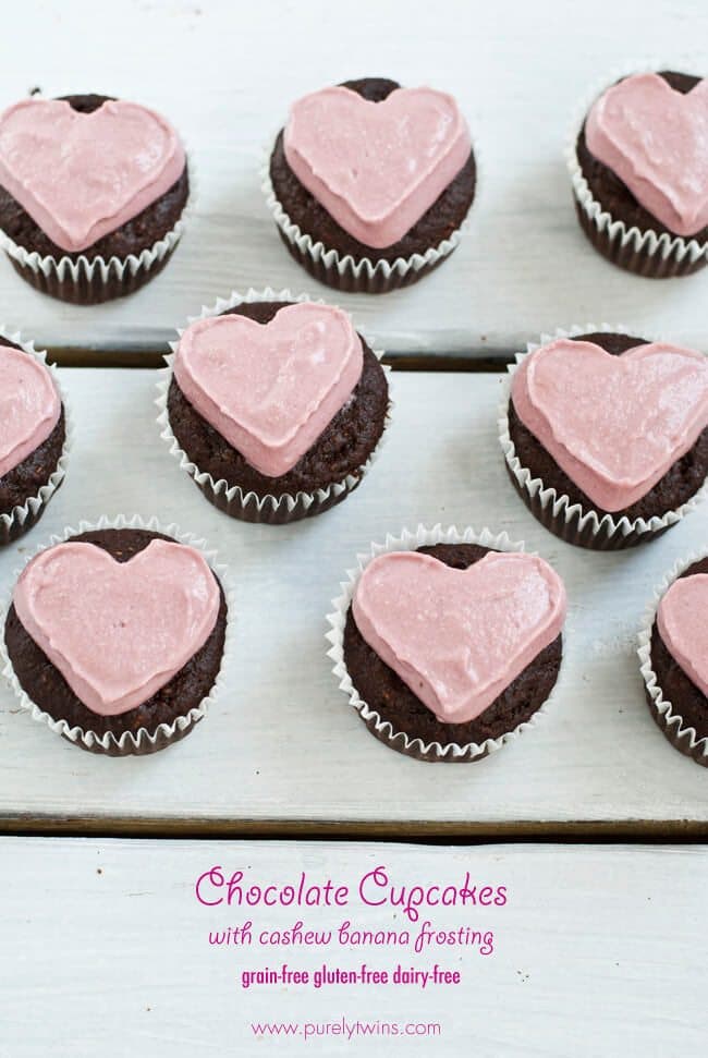 Multiple chocolate cupcakes with pink heart frosting.
