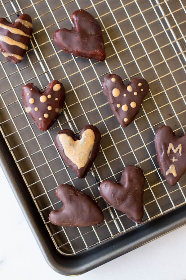 An overhead photo of peanut butter hearts on a cooling wire over a sheet pan.