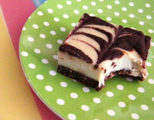 A close up of chocolate swirl cheesecake bar on a plate.