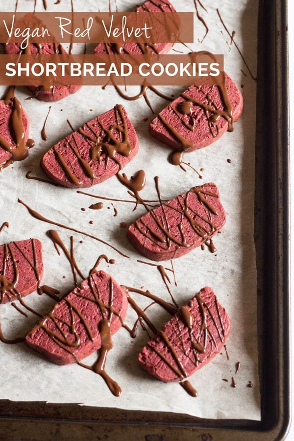A sheet pan with multiple red velvet shortbread cookies.