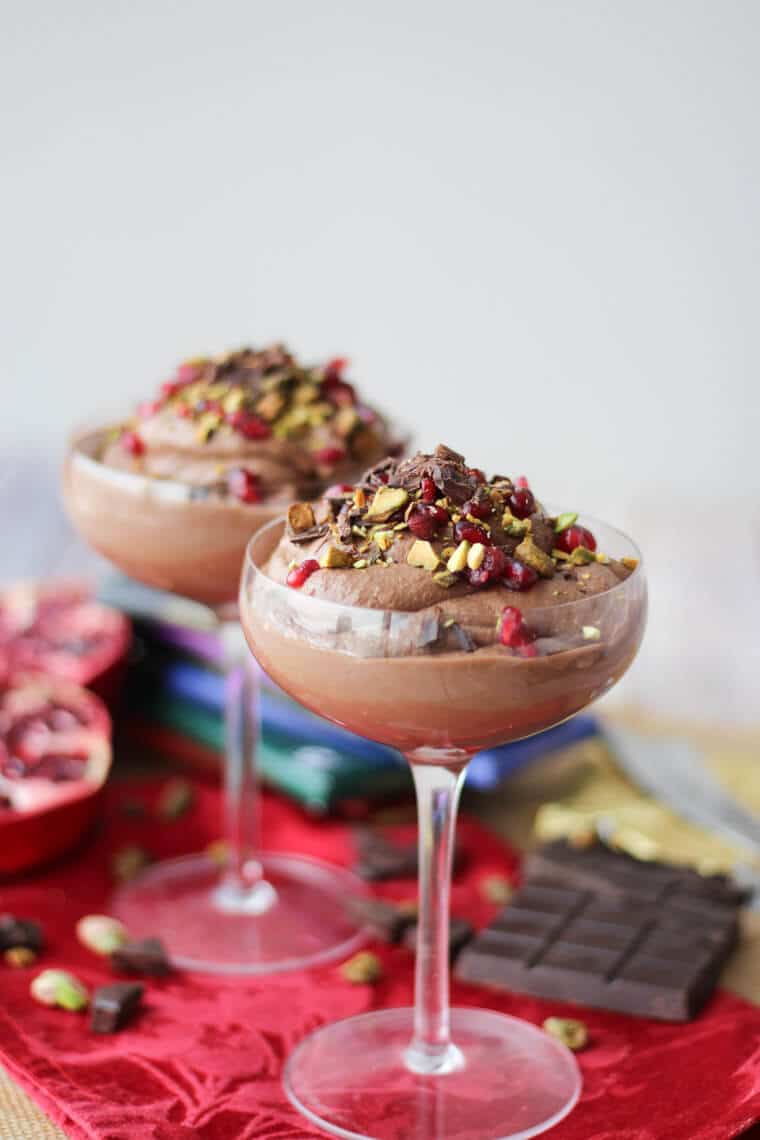 Two glasses of chocolate tahini mousse with pomegranate and pistachios. 