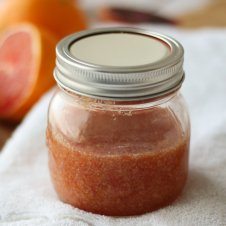 A mason jar with blood orange ginger body scrub.