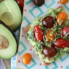 An avocado toast with tomatoes on top.