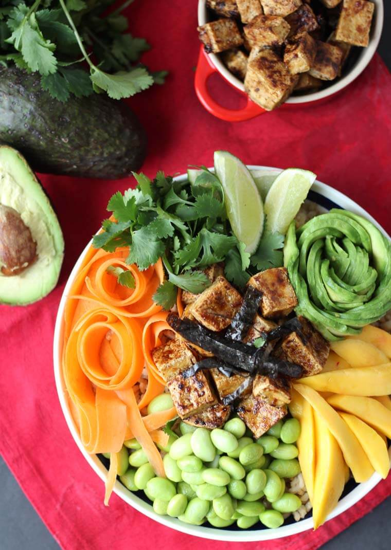 An overhead image of a poke bowl on a red background.