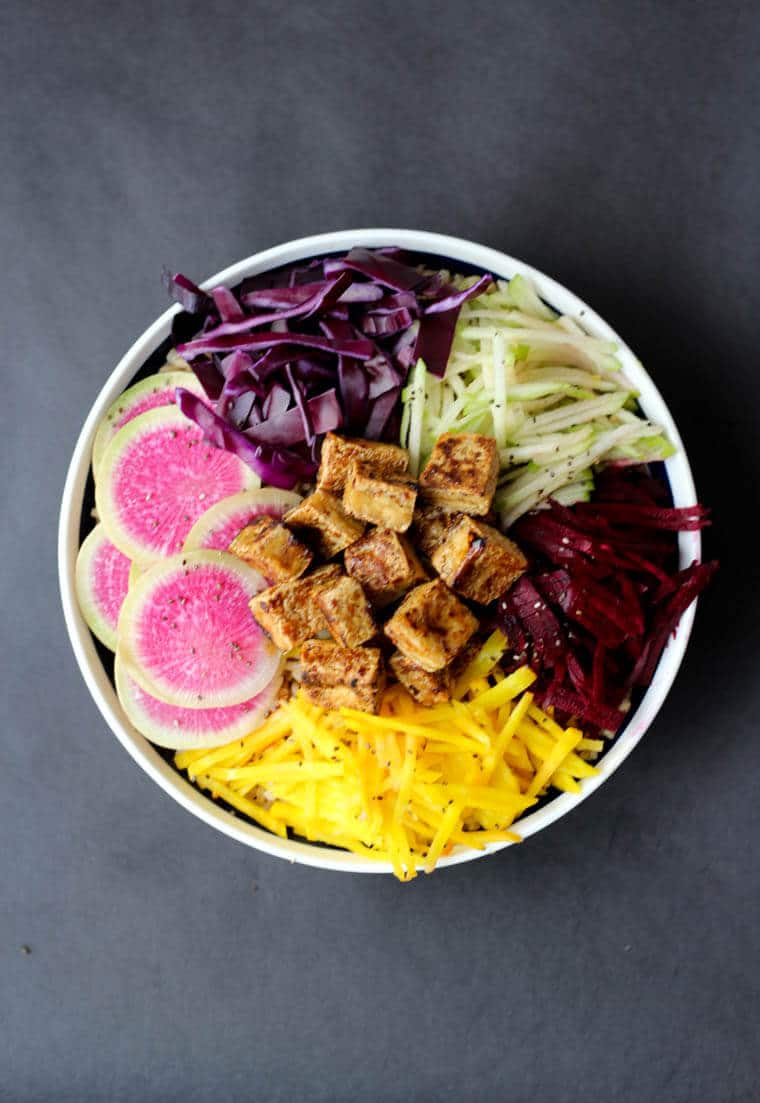 An overhead image of a poke bowl with crispy tofu, radish, cabbage.