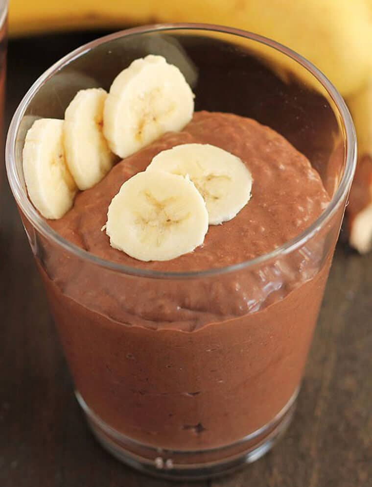 A glass cup of chocolate banana coconut chia pudding.