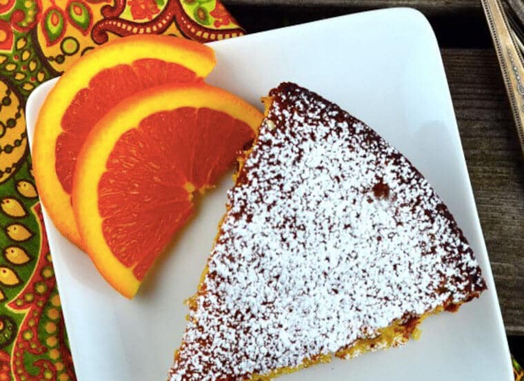 A slice of orange almond honey cake on a plate.