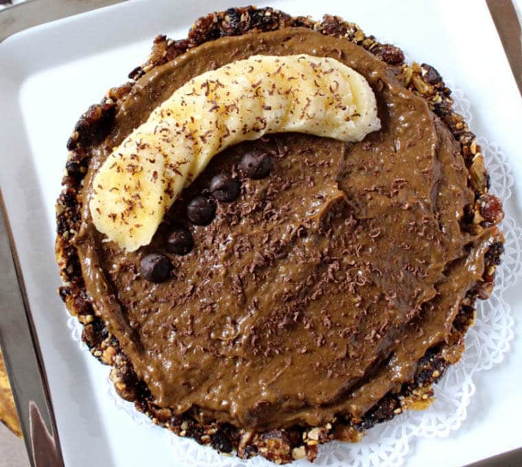 An overhead photo of a vegan chocolate banana pudding pie with sliced bananas on top.