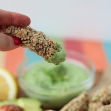 An avocado fry being dipped into a green goddess protein dip.