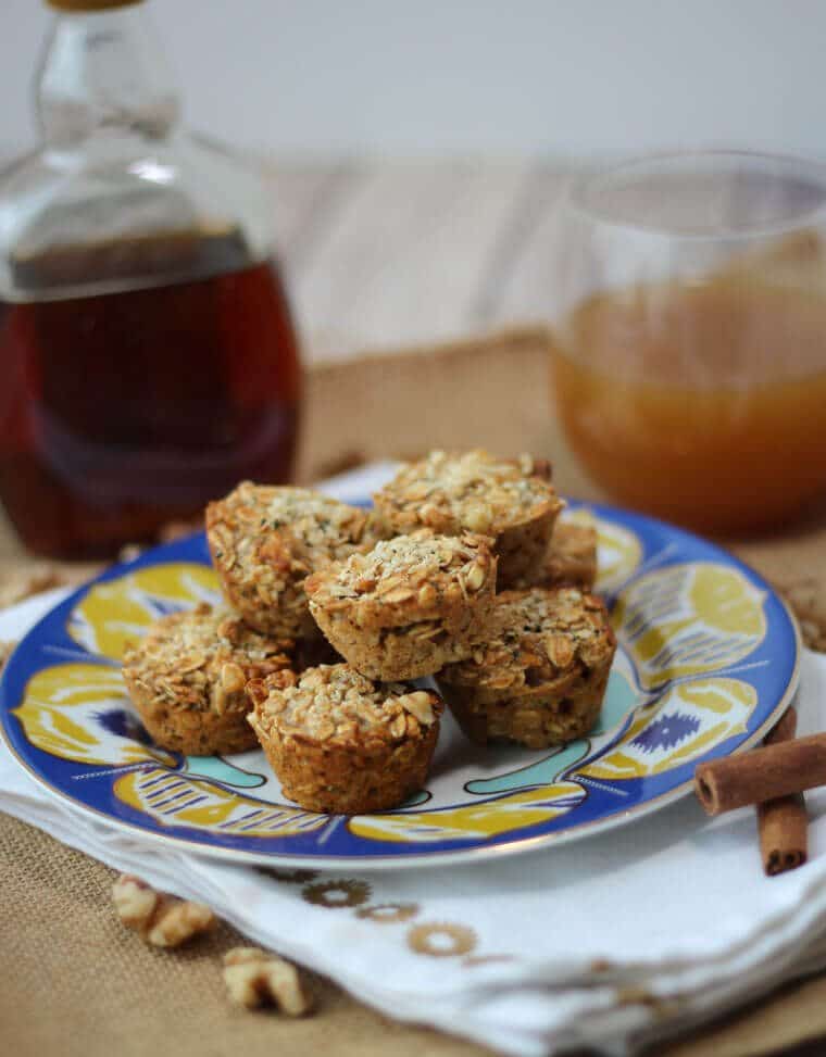 stack of apple protein granola cups on a colourful plate garnished with hemp hearts