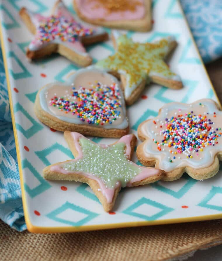 A plate of multiple almond sugar cookies in different shapes.
