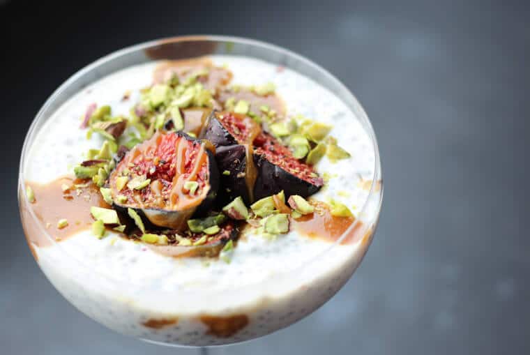 An angled photo of a roasted fig chia pudding with tahini date caramel on top.