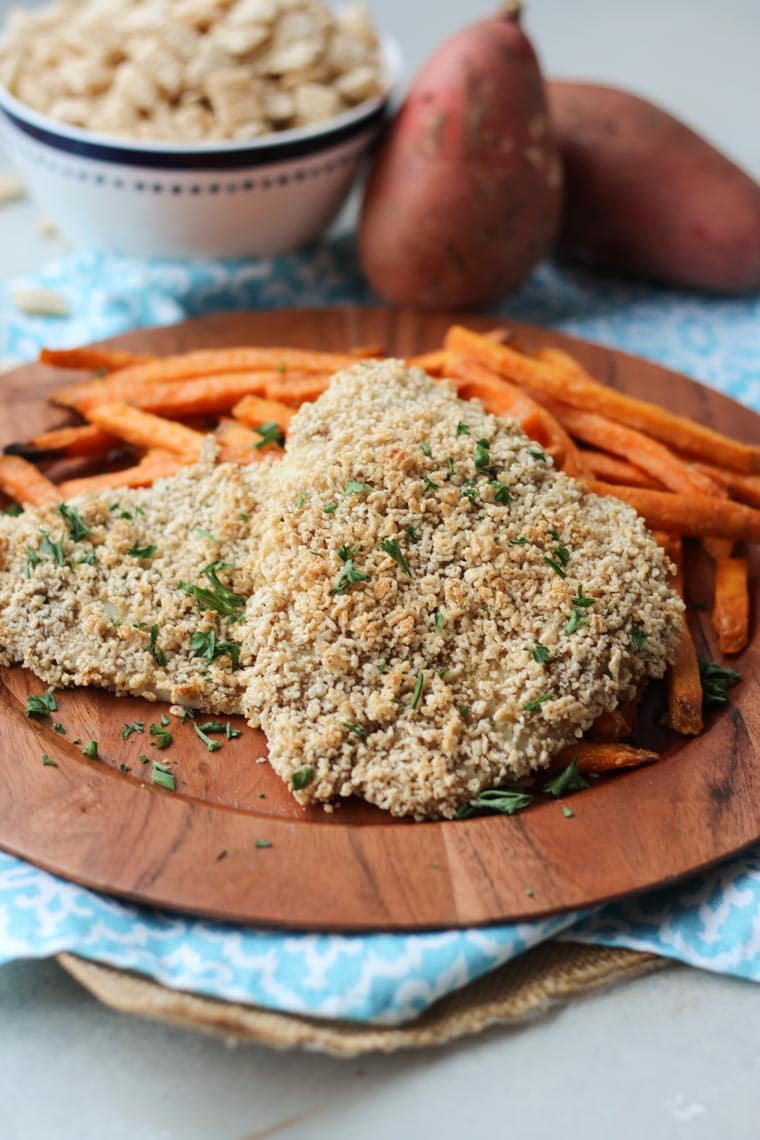 A brown plate with two gluten free fish and sweet potato chips.