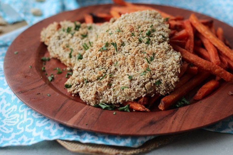 A brown plate with two gluten free fish and sweet potato chips.