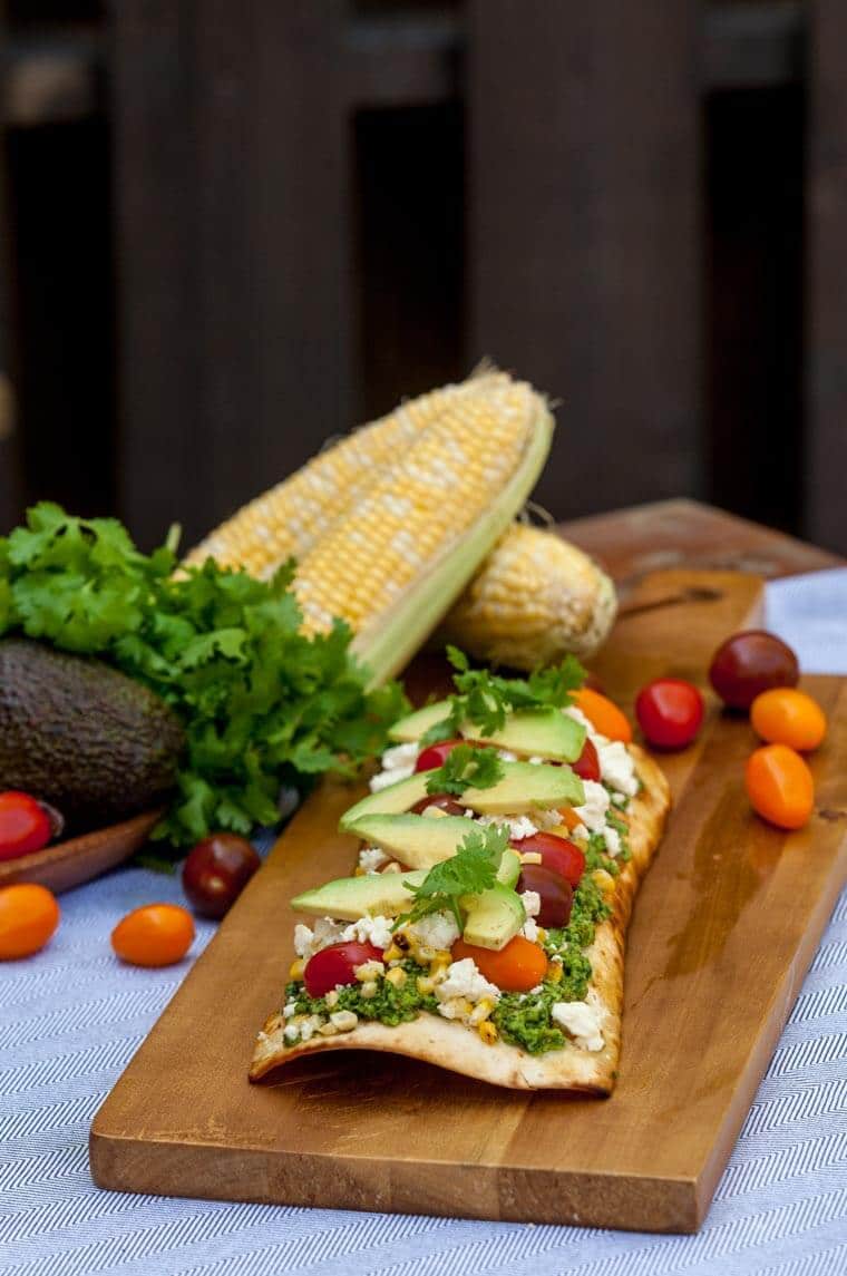 A tasty corn cilantro pesto grilled pizza with pesto, corn, and feta.