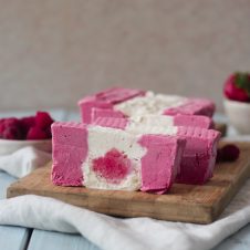 Sliced ice cream cake that looks like a Canadian flag on a serving board.