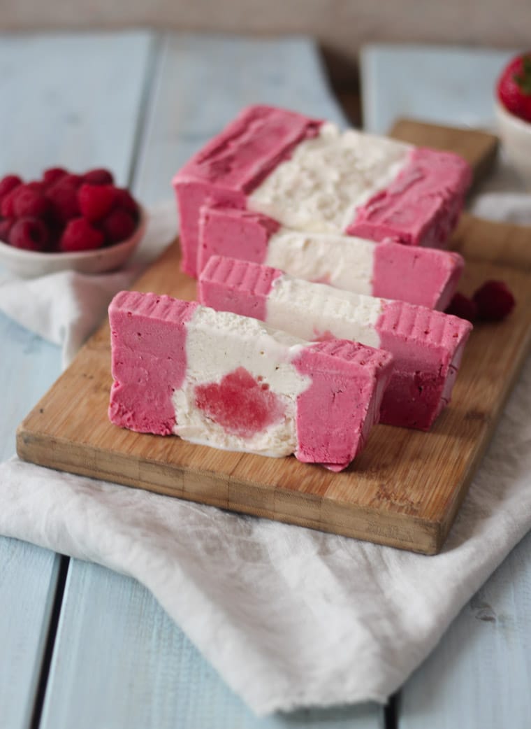 Sliced ice cream cake that looks like a Canadian flag on a serving board.