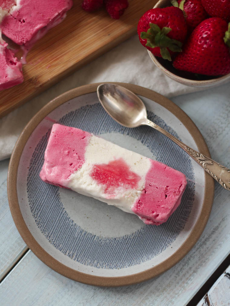 A slice of a canada flag ice cream cake on a plate.