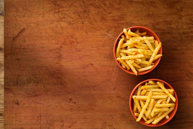 Two red bowls of french fries.