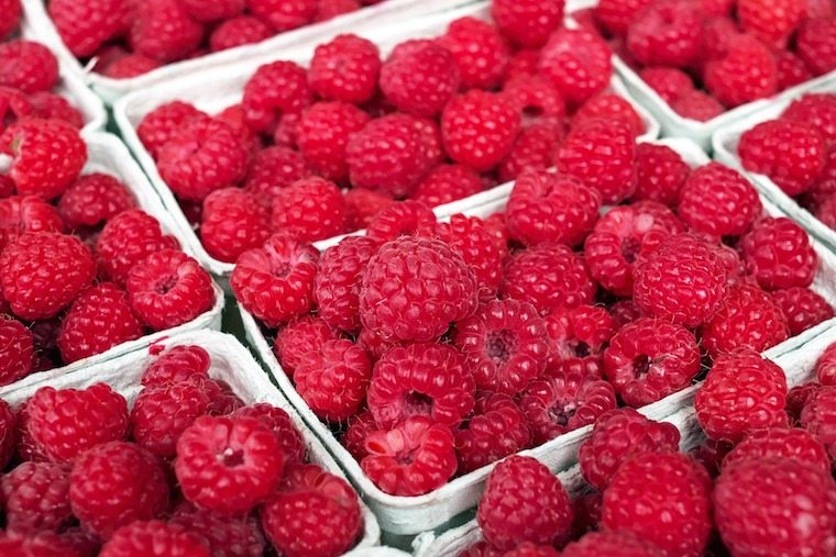A photo of baskets of raspberries.