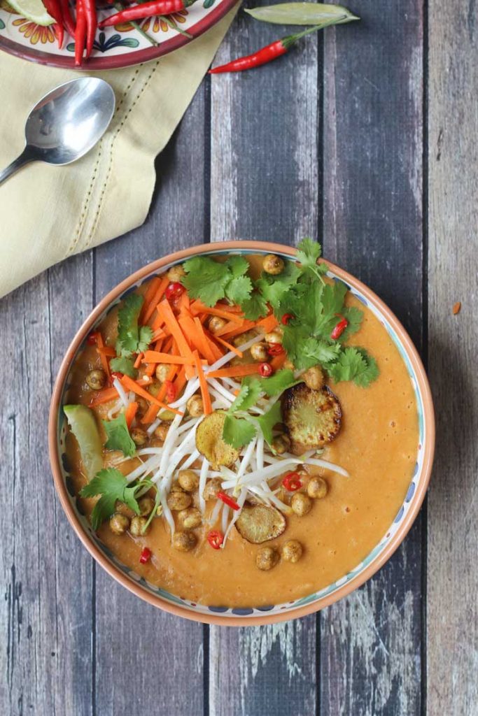 birds eye view of curried sunchoke soup garnished with herbs and vegetables 