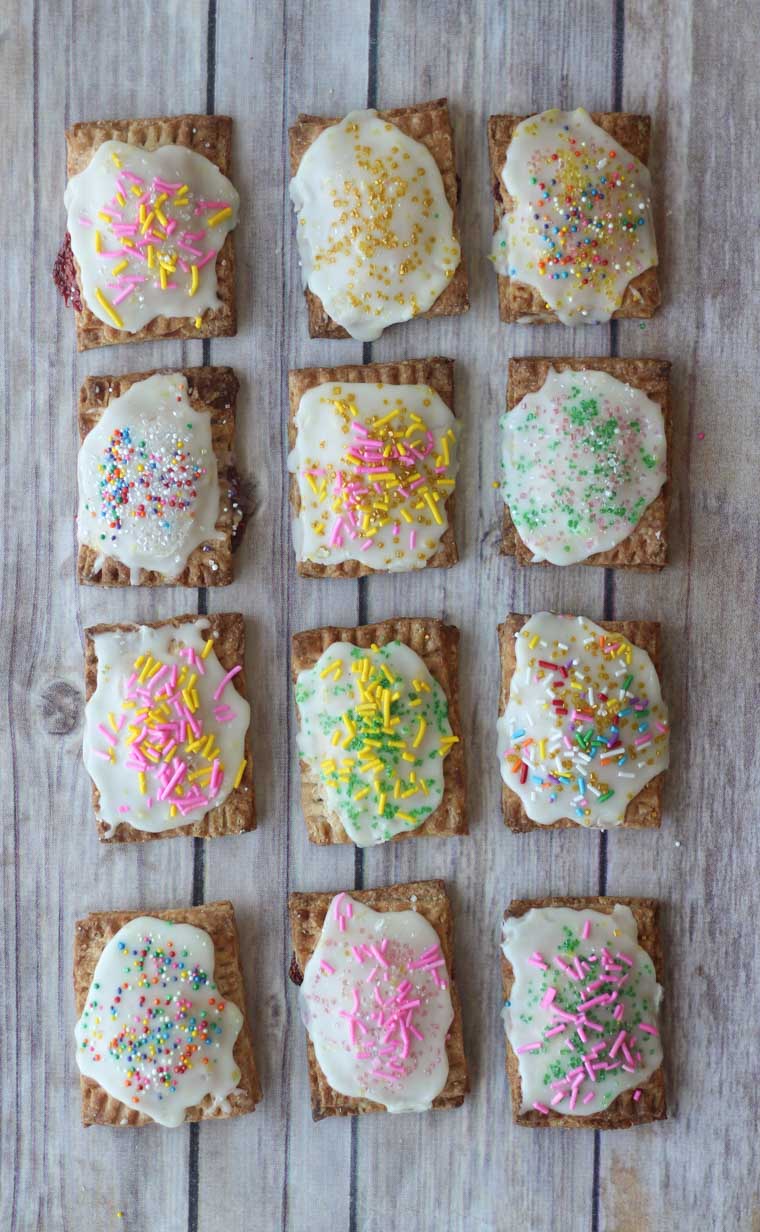 Several homemade pop tarts lined up on a wooden background.