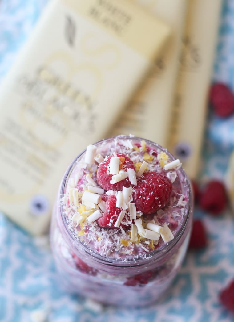 An overhead photo of a mason jar containing white chocolate, lemon, raspberry overnight oats.