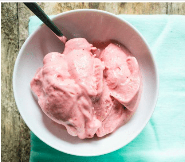 Pink nice cream in a white bowl.