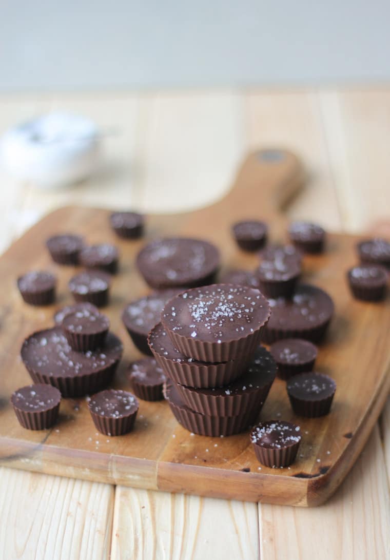 vegan gluten free tahini caramel chocolate cups on a wooden serving board