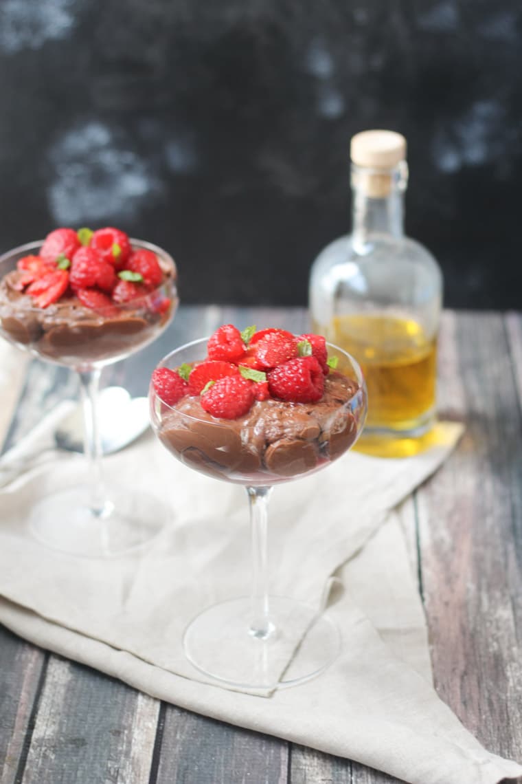 two tall glasses filled with gluten free chocolate mousse topped with berries