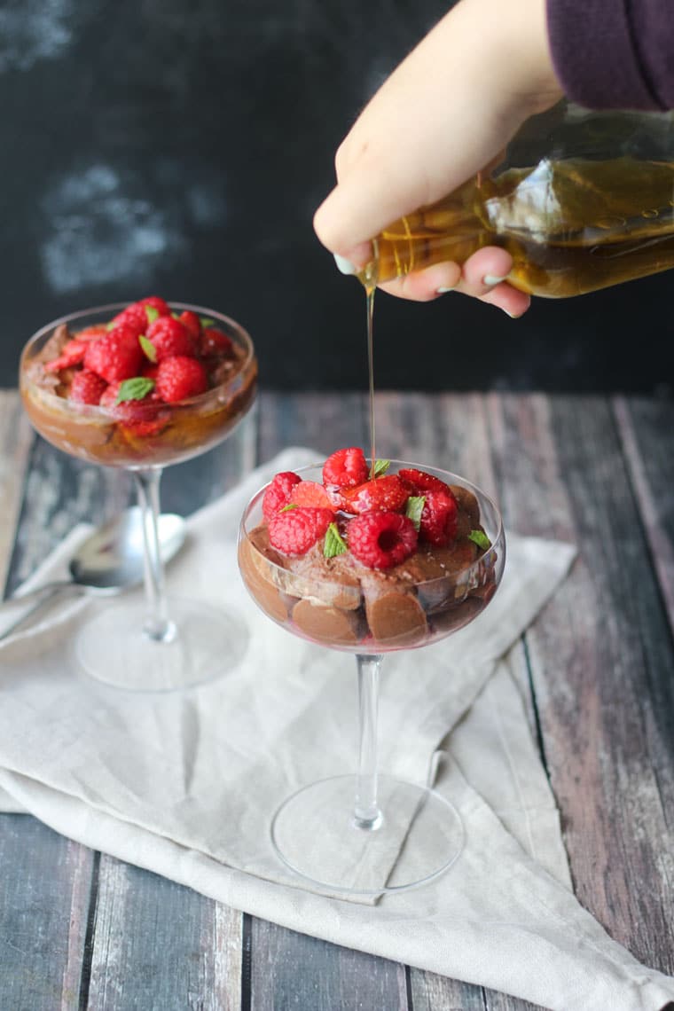 two clear dishes filled with vegan chocolate olive oil mousse garnished with macerated berries