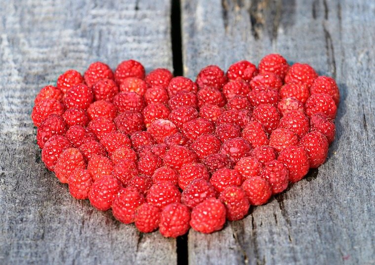 Raspberries placed in the shape of a heart.
