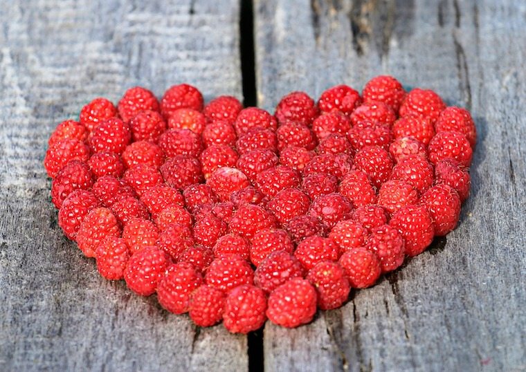Raspberries placed in the shape of a heart.