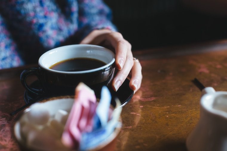 hand holding mug of coffee