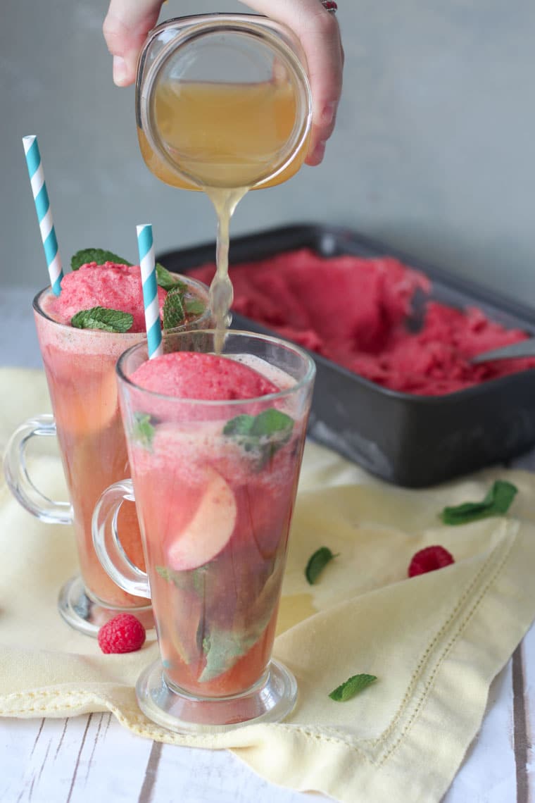 Two glasses of kombucha floats with ice cream in the background.