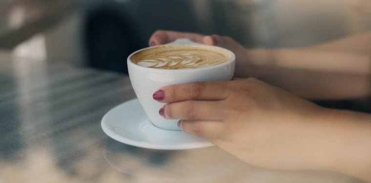 Person holding cup of coffee.