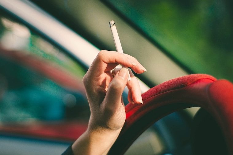 Hand holding a lit cigarette. 