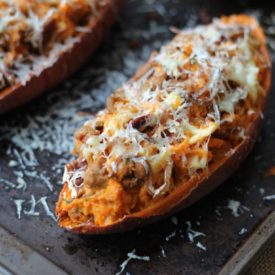 A close up of a baked sweet potato with caramelized onion and apple.